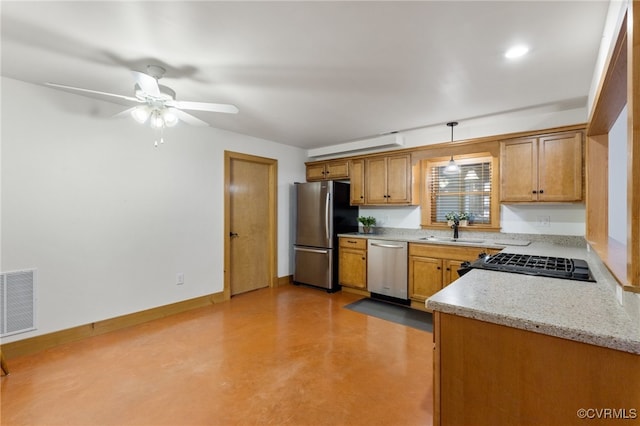 kitchen with hanging light fixtures, sink, ceiling fan, appliances with stainless steel finishes, and light stone counters