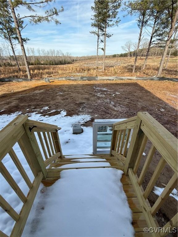 yard covered in snow with a rural view