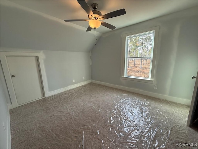 additional living space featuring a ceiling fan, vaulted ceiling, and baseboards