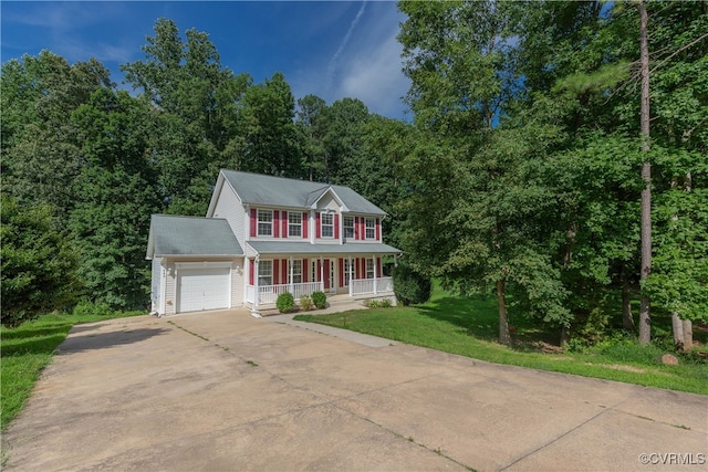 colonial-style house featuring covered porch, a garage, and a front lawn