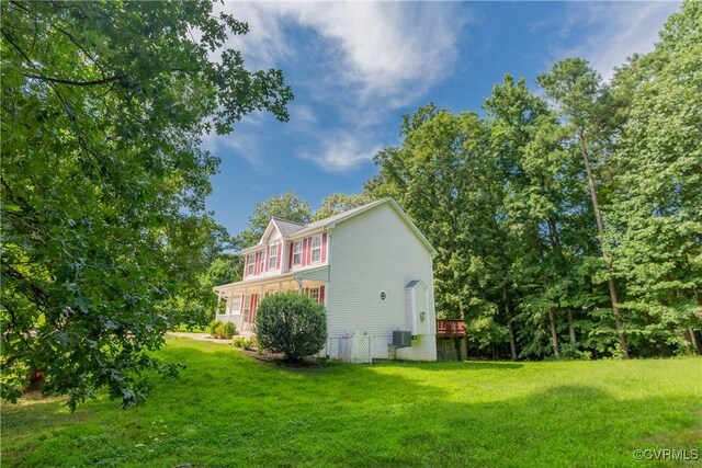 view of home's exterior with a lawn and central AC