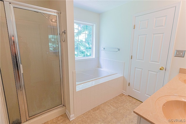 bathroom with tile patterned floors, vanity, and shower with separate bathtub