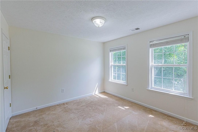 carpeted empty room with a textured ceiling