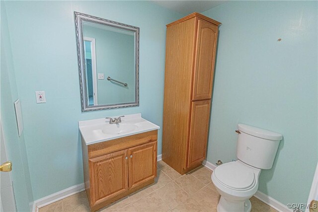 bathroom with tile patterned flooring, vanity, and toilet