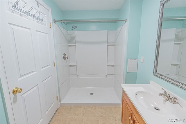 bathroom featuring tile patterned flooring, vanity, and walk in shower