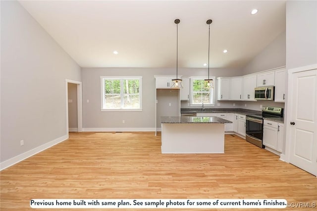 kitchen featuring white cabinetry, a center island, plenty of natural light, decorative light fixtures, and appliances with stainless steel finishes