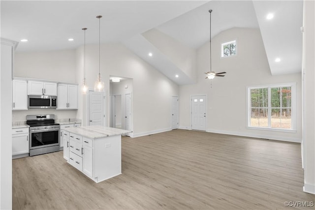 kitchen featuring a wealth of natural light, a ceiling fan, appliances with stainless steel finishes, white cabinets, and light wood finished floors