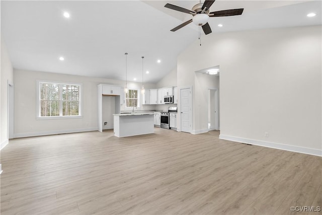 unfurnished living room featuring recessed lighting, high vaulted ceiling, light wood-type flooring, and a ceiling fan