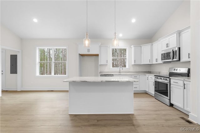 kitchen with visible vents, a kitchen island, vaulted ceiling, electric panel, and stainless steel appliances