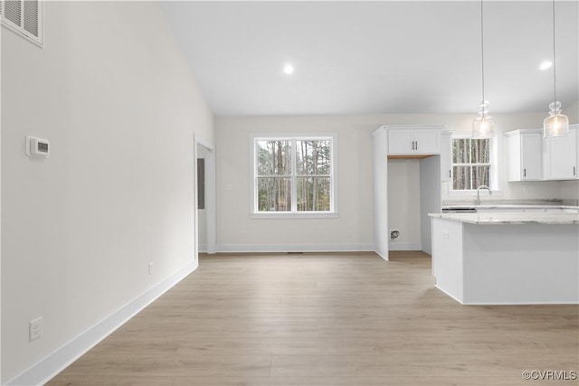 kitchen featuring visible vents, baseboards, light wood-style floors, pendant lighting, and white cabinetry