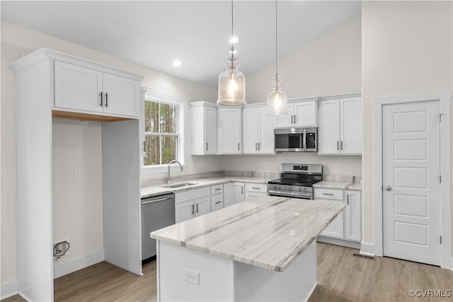 kitchen with a sink, a kitchen island, appliances with stainless steel finishes, and white cabinetry