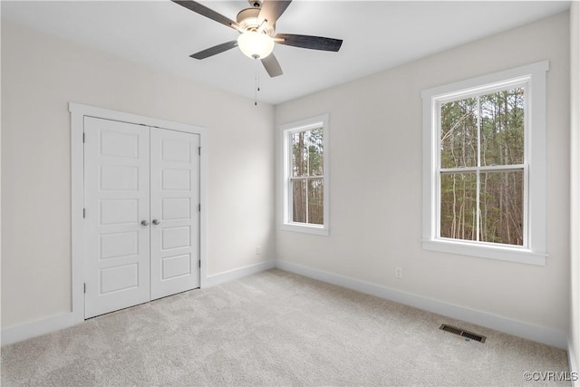 unfurnished bedroom with a ceiling fan, baseboards, visible vents, carpet floors, and a closet