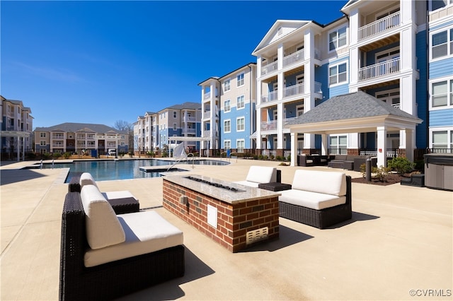 view of pool with a gazebo, a patio area, and an outdoor living space with a fire pit