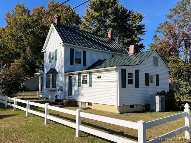 exterior space featuring central AC and a front yard