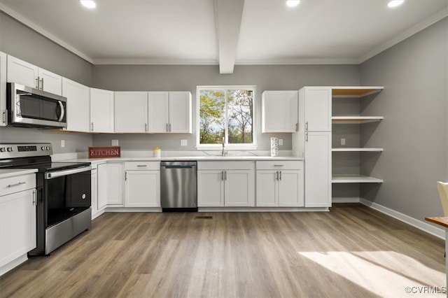 kitchen featuring white cabinets, light hardwood / wood-style floors, ornamental molding, and appliances with stainless steel finishes