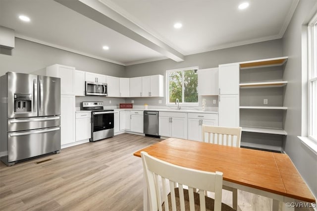 kitchen with stainless steel appliances, crown molding, beam ceiling, light hardwood / wood-style flooring, and white cabinets