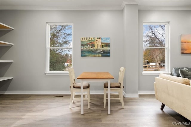 dining area with hardwood / wood-style floors and crown molding