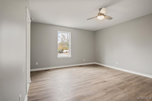 empty room with ceiling fan and light hardwood / wood-style floors