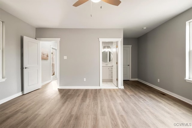 unfurnished bedroom with ceiling fan, light wood-type flooring, and connected bathroom