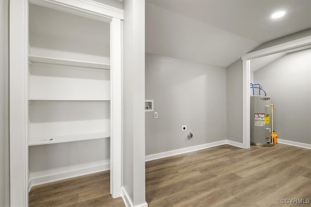 washroom with hookup for an electric dryer, hardwood / wood-style flooring, and water heater