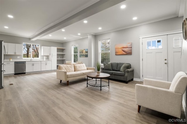 living room featuring sink, beamed ceiling, light hardwood / wood-style floors, and ornamental molding