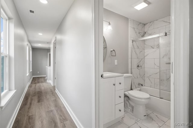 full bathroom with hardwood / wood-style floors, vanity, a healthy amount of sunlight, and combined bath / shower with glass door