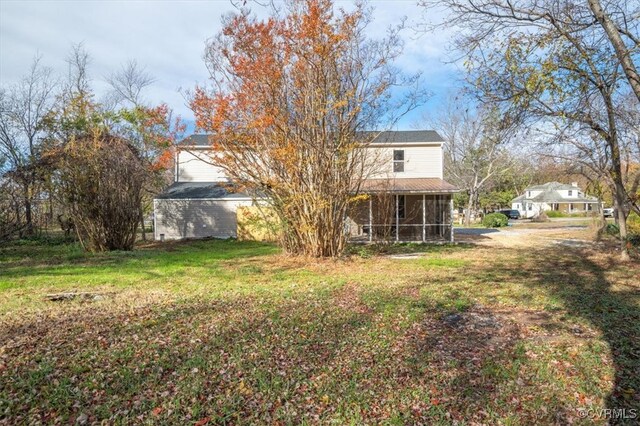 back of house with a yard and a sunroom