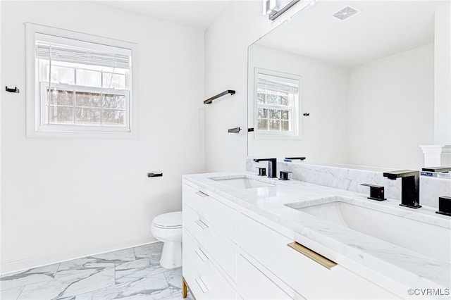 bathroom with a wealth of natural light, vanity, and toilet