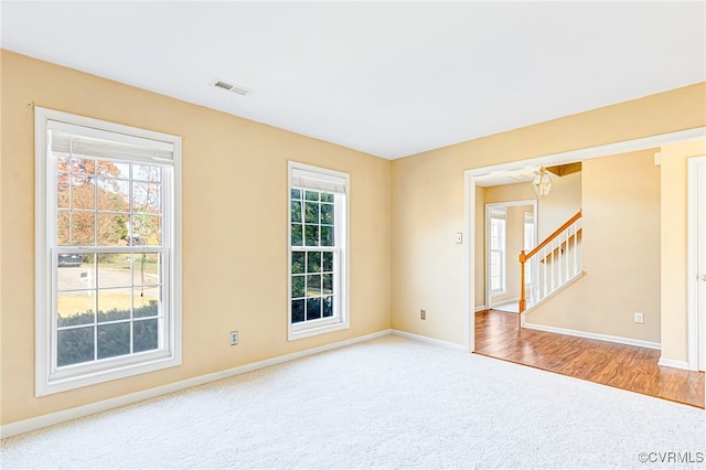 empty room featuring carpet floors and an inviting chandelier