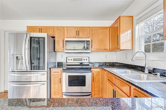 kitchen with dark stone countertops, sink, and appliances with stainless steel finishes