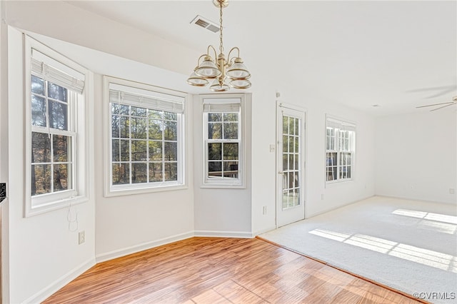 interior space with light hardwood / wood-style flooring and ceiling fan with notable chandelier