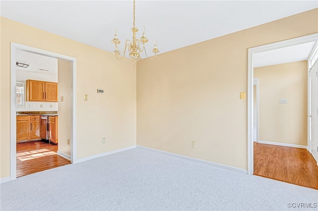 empty room featuring light hardwood / wood-style floors and a notable chandelier