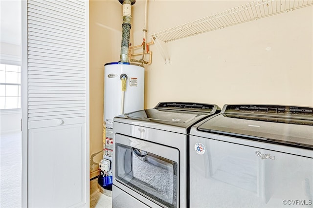 washroom with washer and dryer and gas water heater