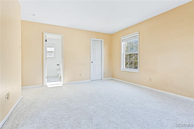 unfurnished bedroom with ensuite bathroom and carpet