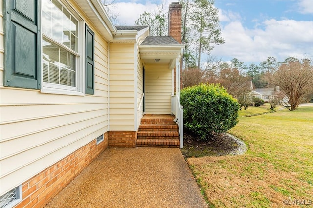 property entrance featuring a lawn