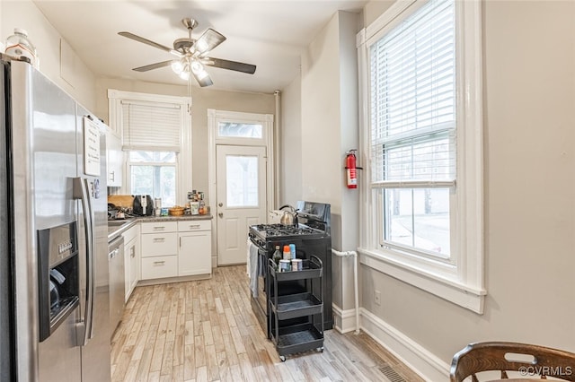 kitchen featuring ceiling fan, light hardwood / wood-style floors, white cabinetry, and appliances with stainless steel finishes