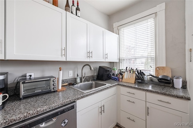 kitchen featuring white cabinets, dishwasher, and sink