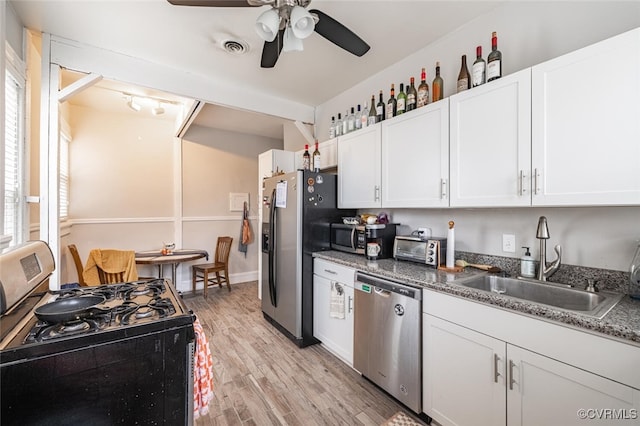 kitchen featuring white cabinets, sink, light hardwood / wood-style flooring, a wealth of natural light, and stainless steel appliances