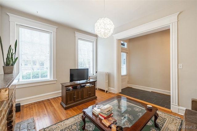 living room with radiator, hardwood / wood-style floors, and a chandelier