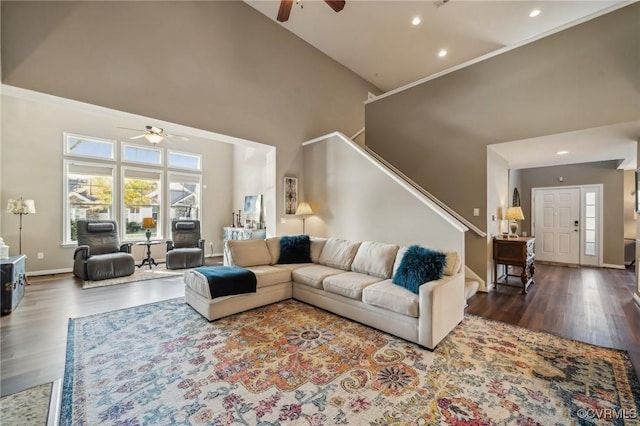 living room featuring dark hardwood / wood-style flooring, high vaulted ceiling, and ceiling fan