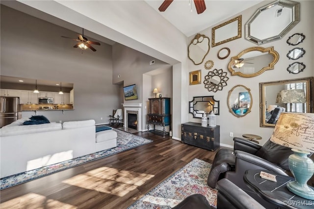 living room with high vaulted ceiling and dark wood-type flooring