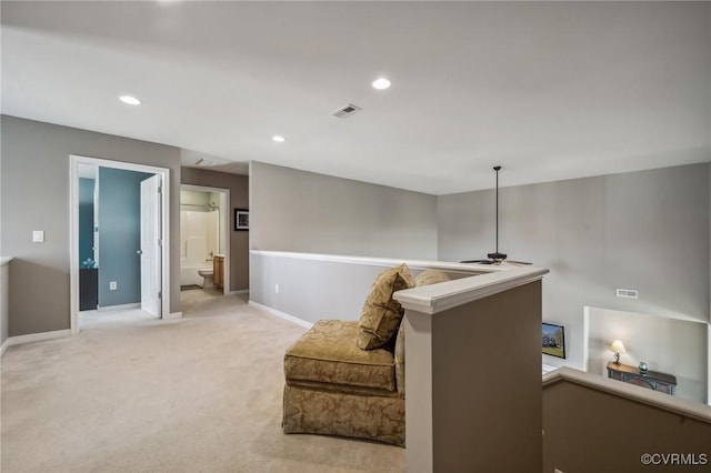 living area featuring light carpet and ceiling fan