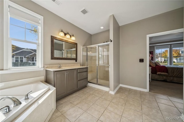 bathroom with tile patterned floors, plenty of natural light, independent shower and bath, and vanity