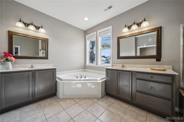 bathroom featuring tile patterned flooring, vanity, and a tub