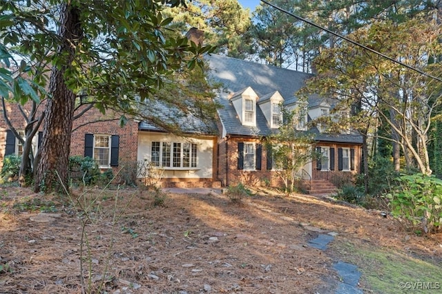 new england style home featuring brick siding