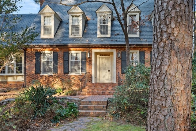 view of front facade featuring a high end roof and brick siding