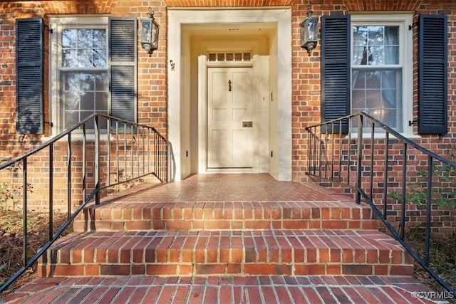 view of exterior entry with brick siding