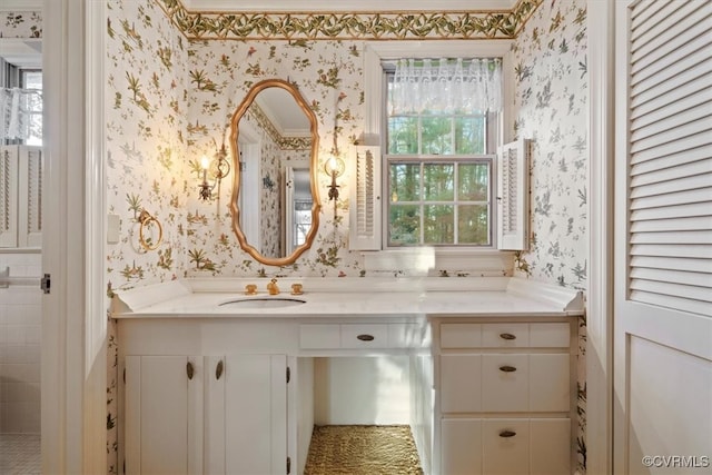 bathroom featuring vanity and wallpapered walls