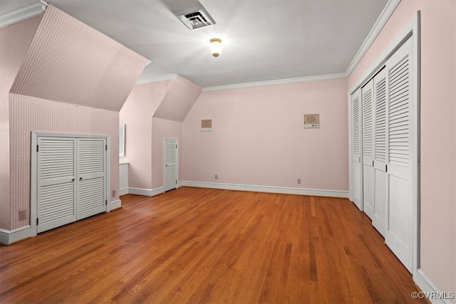 additional living space with visible vents, baseboards, and wood finished floors