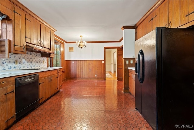 kitchen featuring an inviting chandelier, ornamental molding, black appliances, light countertops, and wainscoting